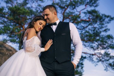 Dağlarda yürüyen iki yeni evli çiftiz. Gelin ve damat ağacın altındaki manzaranın tadını çıkarıyorlar..
