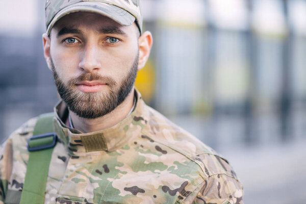 Portrait of a sad desperate young military man, looking pensively at the camera. The soldier suffers from depression, psychological trauma. Post-traumatic stress disorder concept.