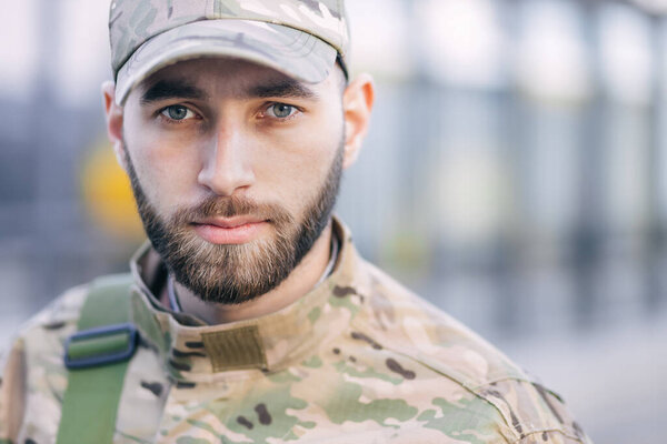 Portrait of a sad desperate young military man, looking pensively at the camera. The soldier suffers from depression, psychological trauma. Post-traumatic stress disorder concept.