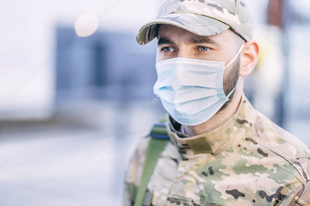 a soldier of the National Armed Forces monitors the safety of people, following the rules, adhering to the COVID-19 prevention protocol, wearing a mask