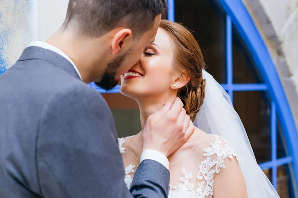 Jonge Liefdevolle Bruid Bruidegom Knuffelen Kussen Buurt Van Blauwe Ramen — Stockfoto