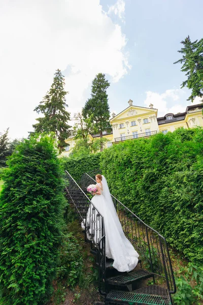 Nevěsta Nádherných Šatech Stojí Schodech Schodech Pozadí Hradu Listí — Stock fotografie