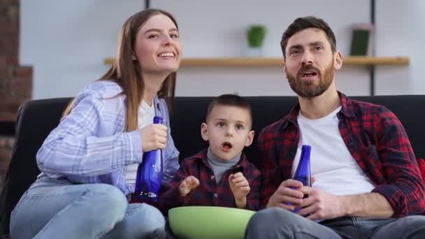 Familie Sitzt Hause Auf Sofa Isst Popcorn Und Guckt Gemeinsam — Stockvideo