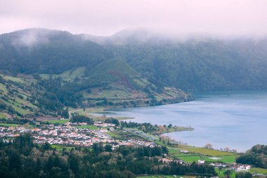Orman ve göl kenarında güzel evleri olan küçük bir köyün manzarası. Portekiz. açore adaları.