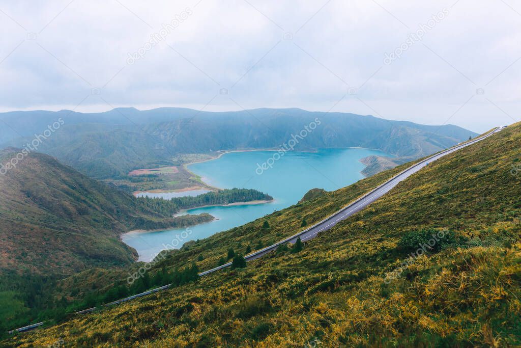 Panoramic landscape with beautiful blue crater lake Lagoa do Fogo in Natural Reserve with green forest, mountains and hills, sea coast.