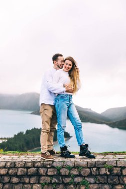 Genç bir çift gölün panoramik manzarasının tadını çıkarıyor. Azores.