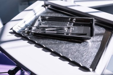 Diş sağlığı kliniğindeki diş telleri için çeşitli paslanmaz çelik aletlere yakından bakın. Diş hekimliği, ortodonti ve tıbbi aletler kavramı.