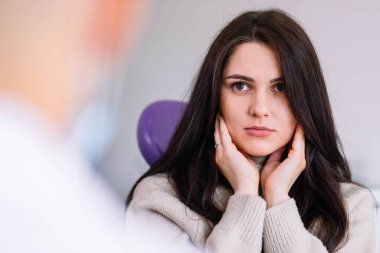 Diş ağrısından muzdarip güzel üzgün kıza yakın çekim. Diş sağlığı sigortası stresli bir kavram. Dişçide resepsiyon. 