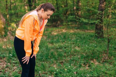 Dışarıda koştuktan sonra dinlenen yorgun genç bir kadın. Kopya alanı olan sağlıklı kız yaşam tarzı