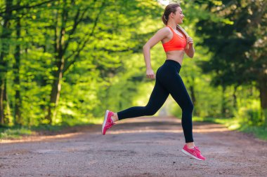 Açık havada koşan genç bir kadının yan görünüş portresi. Fotoğraf çekiliyor. Boşluğu kopyala