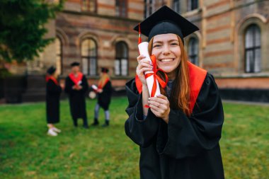 Elinde diplomayla mutlu bir lisansüstü öğrencisi. Mutluluktan bağır, Joy. Kadın üniversiteden onur derecesiyle mezun oldu..