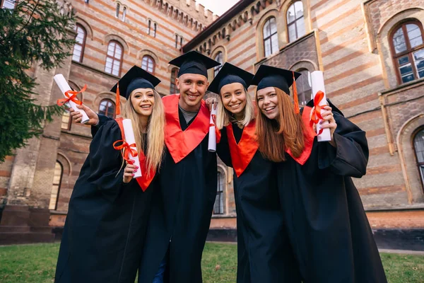 Graduados Abraçar Desfrutar Olhar Para Câmera Cerimônia Formatura — Fotografia de Stock