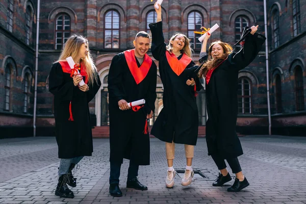 Alegre Satisfeito Estudantes Saltando Regozijo Final Seus Estudos Segurando Mãos — Fotografia de Stock