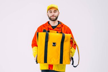 Okuldan sonra genç bir adam ek iş olarak kuryelik yapıyor. Elinde sarı bir termal çanta var ve sipariş bekliyor..