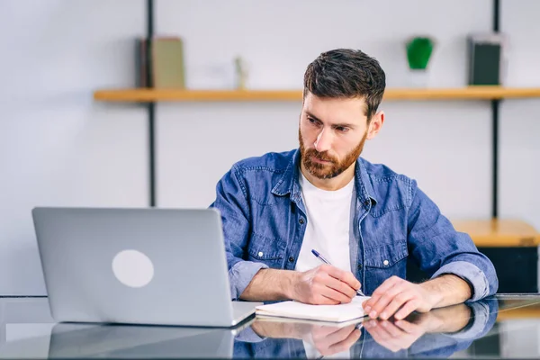 Hombre Negocios Serio Trabajando Una Computadora Portátil Escribiendo Algo Cuaderno —  Fotos de Stock