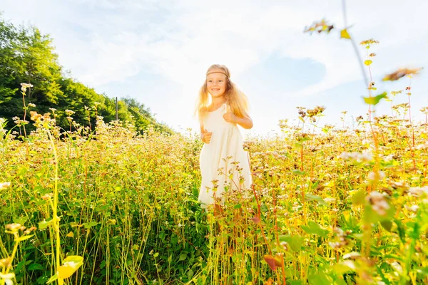Радісна Маленька Дівчинка Біжить Білій Сукні Протікаючим Волоссям Жовтій Підлозі — стокове фото