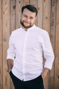 Kırsal kesimde, beyaz gömlekli yakışıklı bir adam..