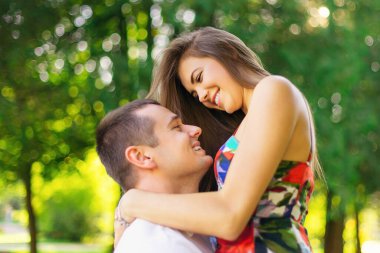 Sevecen bir çift parkta yürüyor. Bir adam bir kadını kollarında tutuyor. Aşk hikayesi..