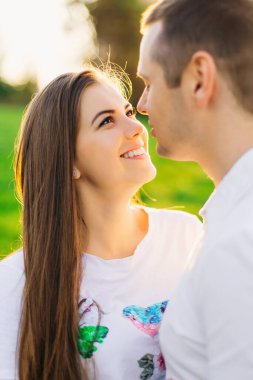 Young couple in love outdoors hugging and laughing together, having a good time.