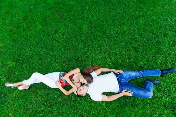 幸せなカップル 恋人たちは草の上に横たわっている 長い黒い髪と若い男を持つ美しい女の子 幸せなカップル 自然の概念 — ストック写真