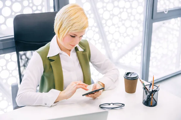 Widok Boczny Businesswoman Pracy Komputerem Korzystania Smartfona Podczas Siedzenia Nowoczesnym — Zdjęcie stockowe