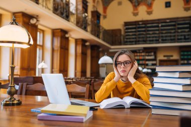 Stresli kolej öğrencisi sınavlarda kitap ve dizüstü bilgisayarla zor öğrenmekten, sınavlara hazırlanmaktan, liseli kızların zor çalışmalardan ya da çok fazla ödevden bitkin düşmesinden yoruldu..