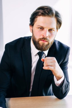 İş adamı profesyonel ofis işyerinde güven içinde poz veriyor. Klasik takım elbiseli, kravatlı..