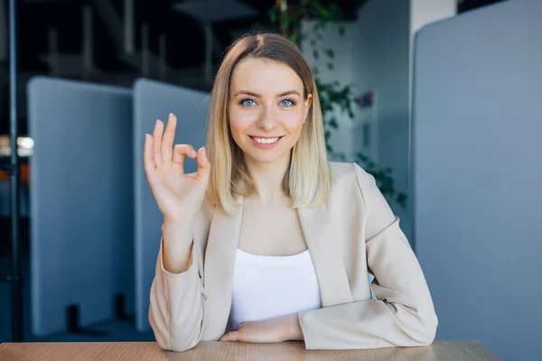 Allegro Donna Affari Bionda Abiti Formali Mostrando Gesto Mentre Seduto — Foto Stock