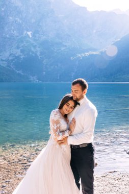 Birbirine aşık bir çift, yeni evliler, beyaz elbiseli bir gelin ve yazın nehir kenarında dağların arkasında yürüyen takım elbiseli bir adam..