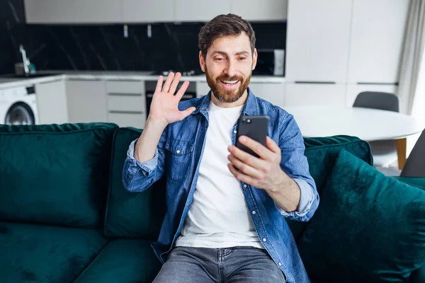 Genç Bir Adam Kanepede Oturuyor Elinde Akıllı Bir Telefon Var — Stok fotoğraf