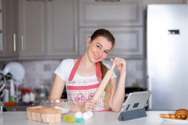 Mutfakta merdaneli önlüklü bir kadın.