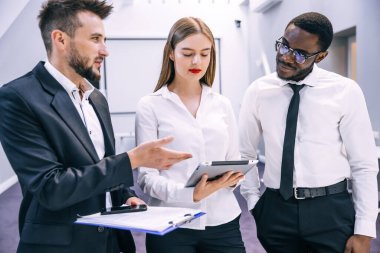 Ofisteki iş adamları teknolojiyi konuşuyor ve kullanıyor..