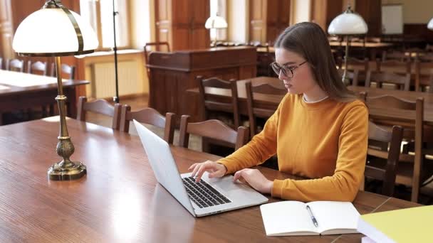 Student Střední Školy Uniformě Pracuje Laptopu Knihovně Otevřeným Zápisníkem Připravuje — Stock video