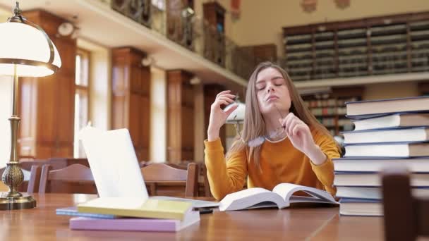 Uma Estudante Cansada Exausta Está Sentada Biblioteca Uma Mesa Com — Vídeo de Stock