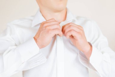 Damat düğmelerini ilikliyor beyaz gömlek