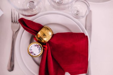 Restoranda kompozisyon ile birlikte akşam yemeği için alışılmadık kırmızı tonlarda bir masa. Düğün ziyafeti süslemeleri ve yemek malzemeleri beyaz masada yemek servisi tarafından düzenlenir.