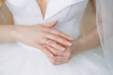 Gelinin nazik elleri, beyaz elbiseli, parmağında alyansla.