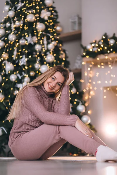 Ευτυχισμένη Γυναίκα Κάθεται Δίπλα Στο Τζάκι Κοντά Στο Χριστουγεννιάτικο Δέντρο — Φωτογραφία Αρχείου