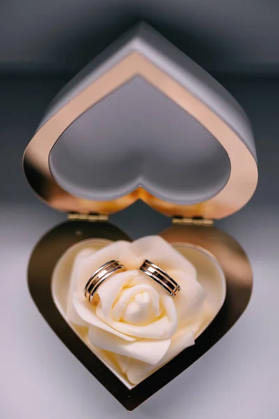 gold wedding rings in box with flower