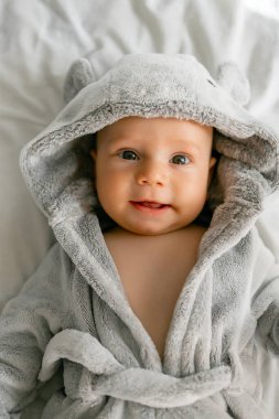 Kapüşonlu, gri bornozlu yakışıklı bir oğlan.