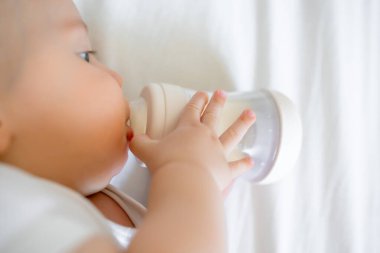 Şişeden içen tatlı bir erkek bebek. Çocuk yuvasında yatıyor.