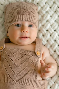 3 aylık şirin bir bebeğin battaniyeye uzanmış portresi.