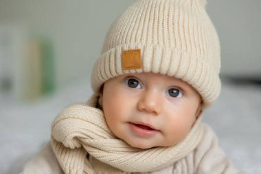 Kışın örülmüş şapka takan şirin bir bebeğin portresi.