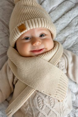 Yeni doğmuş sevimli erkek bebek örgü örüp kameraya bakıyor..