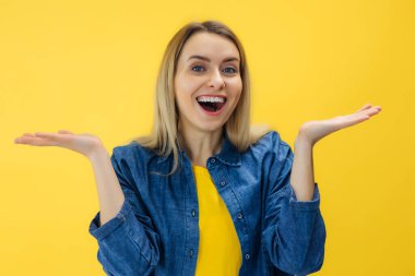 Şaşırmış güzel bir kız sarı arka planda ağzı açık kalmış..