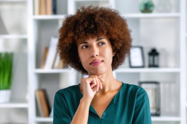 Düşünceli siyahi iş kadını, düşünceli yüzünü çevirmiş, hayaller kuruyor, projeler üzerinde düşünüyor, problem çözüyor.