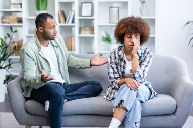 Erkek arkadaş ve kız arkadaş evde tartışıyor. Kızgın adam üzgün kız arkadaşına bağırıyor..