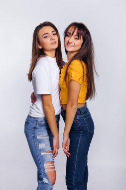 Kızlar kameraya sarılıp gülümsüyor. Moda fotoğrafı. biçim.