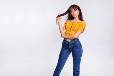 Beyaz arka planda poz veren kot ve bluzlu genç bir kadın. Stüdyo. makyaj.