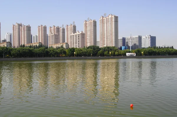 Ciudad de Datong (Shanxi, China). Casas de apartamentos en la orilla del río Fotos de stock